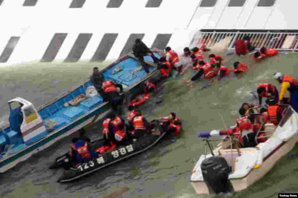 한국 목포해경 대원들이 16일 전남 진도 해역에서 세월호 침몰 직전 승객을 구조하고 있다.