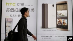 A man walks past an HTC smartphone billboard in Taipei, Taiwan, Sept. 21, 2015.