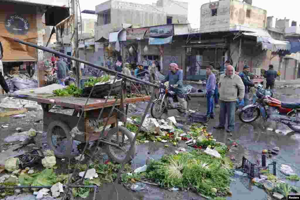 Residents inspect a site after hit by what activists said were air strikes by forces loyal to Syria&#39;s President Bashar al-Assad in Raqqa, Nov. 25, 2014.