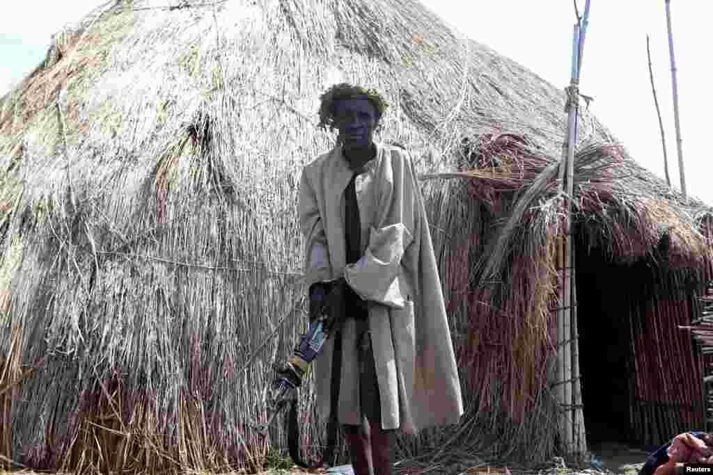 A royal guard for Charles Wesley Mumbere, king of the Rwenzururu kingdom, is seen handcuffed after Uganda security agencies apprehended him with assault rifles and improvised explosive devices during a search at one of the kingdom’s shrines, near Kasese town, Uganda, which borders the Democratic Republic of Congo, Nov. 29, 2016.