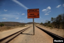 A sign that reads "Take care men working" stands along the construction of the Transnordestina railway track in Missao Velha, Ceara state, Brazil, Oct. 25, 2016.