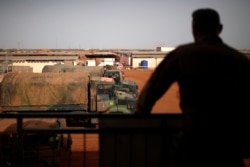 FILE - A French soldier is silhouetted as he looks out over military vehicles in Gao, Mali, Aug. 1, 2019.