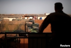 FILE - A French soldier is silhouetted looking at military vehicles in Gao, Mali, on August 1, 2019.