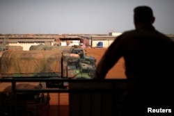 FILE - A French soldier is silhouetted as he looks out over military vehicles in Gao, Mali, Aug. 1, 2019.