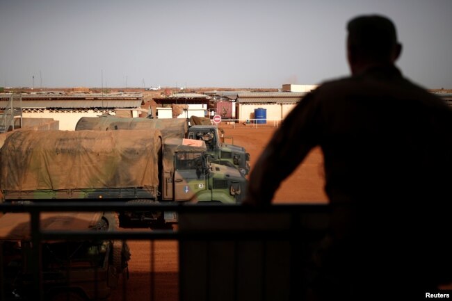 FILE - A French soldier is silhouetted as he looks out over military vehicles in Gao, Mali, Aug. 1, 2019.