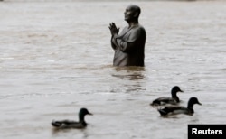 Ducks waddle past the statue of world harmony leader Sri Chinmoy, partially submerged by the water from the rising Vltava river, in Prague. Czech Republic, June 2, 2013.