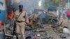 A Somali soldier walks near wreckage of vehicles after a car bomb was detonated in Mogadishu, Oct 28, 2017. 