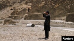 A member of Pakistan's Frontier Corps uses binoculars to survery the border region outside Torkham, Pakistan, June 16, 2016. 