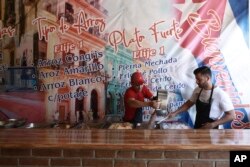 Cuban migrant Danil Hernandez, right, prepares to serve up traditional Cuban food to customers at Little Habana restaurant in Ciudad Juarez, Mexico, April 25, 2019.