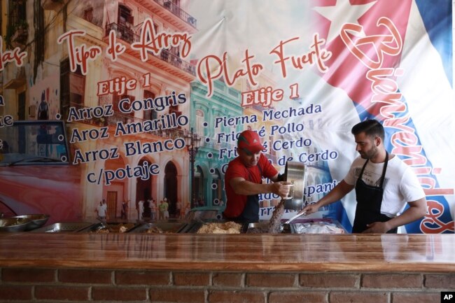 Cuban migrant Danil Hernandez, right, prepares to serve up traditional Cuban food to customers at Little Habana restaurant in Ciudad Juarez, Mexico, April 25, 2019.