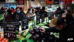北京居民在一家超市挑选蔬菜。（2021年2月10日）