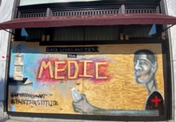 A mural designed by Washington-based artist Levi Robinson showing a black medic adorns the exterior wall of a restaurant on the recently named Black Lives Matter Plaza in Washington, DC, U.S. June 14, 2020. REUTERS/Katanga Johnson