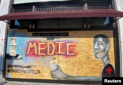 A mural designed by Washington-based artist Levi Robinson showing a black medic adorns the exterior wall of a restaurant on the recently named Black Lives Matter Plaza in Washington, DC, U.S. June 14, 2020. REUTERS/Katanga Johnson