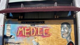 A mural designed by Washington-based artist Levi Robinson showing a black medic adorns the exterior wall of a restaurant on the recently named Black Lives Matter Plaza in Washington, DC, U.S. June 14, 2020. REUTERS/Katanga Johnson
