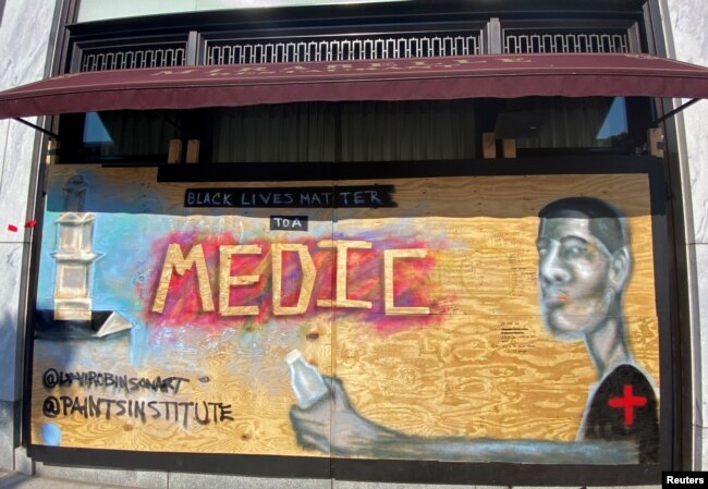 A mural designed by Washington-based artist Levi Robinson showing a black medic adorns the exterior wall of a restaurant on the recently named Black Lives Matter Plaza in Washington, DC, U.S. June 14, 2020. REUTERS/Katanga Johnson