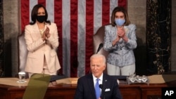 Joe Biden fala ao congresso, com vice-presidente Kamala Harris (esq) e a presidente da Câmara dos Representantes, Nancy Pelosi (dir)