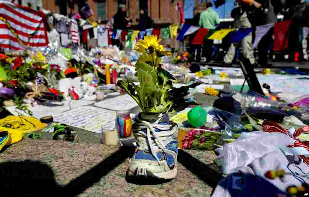 A memento of flowers in a running shoe rests at a makeshift memorial in Boston's Back Bay neighborhood, April 18, 2013, a few blocks from the finish line of the Boston Marathon.