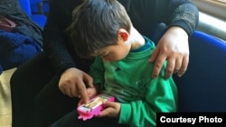 Mohammed, age 5, uses his mother's smartphone to play games earlier this year. Before his family fled from the Syrian city of Aleppo to Istanbul, Mohammed’s grandfather was killed. (photo courtesy Liv Marte Nordhaug)