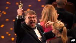 Guillermo del Toro, winner of the award for best director for "The Shape of Water" celebrates in the audience at the Oscars, March 4, 2018.