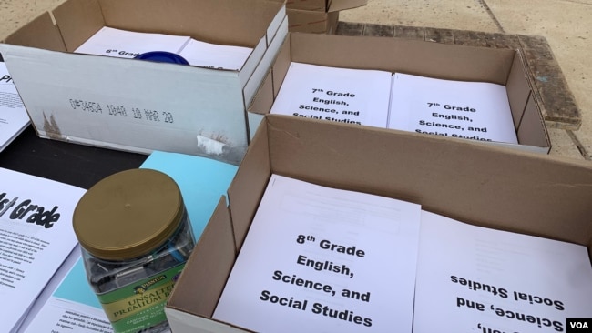 Estudiantes recogen material educativo tras cierre de escuelas por coronavirus.