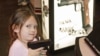 A young attendee tries out a pistol during the National Rifle Association's (NRA) 141st Annual Meetings & Exhibits in St. Louis, Missouri, April 13, 2012.