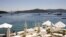 A woman sunbathes on a near-deserted deck as luxury boats are seen anchored off the beach front of a hotel in Golturkbuku, near the resort town of Bodrum on the southwest Aegean coast of Turkey, July 17, 2007. 
