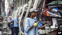 FILE - Employees at the Volkswagen plant in Chattanooga, Tenn., work on the assembly of a Passat sedans, July 12, 2013. 