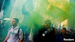 Italian League (Lega) supporters hold flares as they arrive at political rally led by leader Matteo Salvini, in Milan, Italy, Feb. 24, 2018.