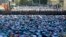 Muslim men, bowing toward Mecca, offer Eid al-Fitr prayers that marks the end of the holy fasting month of Ramadan as police guard them at the main mosque in Moscow, Russia.