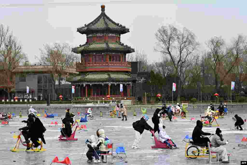 People use ice cycles to skate on the frozen surface of Houhai lake in Beijing, China.