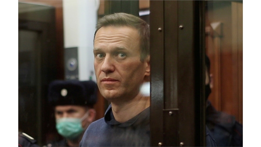 FILE - A still image taken from video footage shows Russian opposition leader Alexey Navalny inside a defendant dock during the announcement of a court verdict in Moscow, Russia, Feb. 2, 2021.
