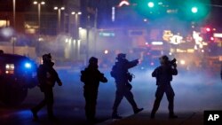 FILE - In this May 30, 2020, file photo, police walk through tear gas as they try to disperse protesters in Las Vegas. 
