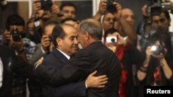 Shugaban majalisar mulkin wucin gadi, Mustafa Abdel Jalil (dama) yana gaisawa da firayim ministan zamanin yaki,Mahmoud Jibril 8 Agusta 2012