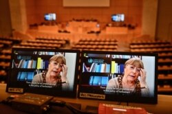 FILE - United Nations High Commissioner for Human Rights Michelle Bachelet is seen on a screen as she speaks via video-link during a session of the U.N. Human Rights Council, in Geneva, Feb. 25, 2021.