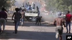 Sudanese confront the police Wednesday during a protest against the military coup that ousted government last month, in Khartoum, Sudan