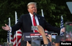 ARCHIVO - Partidarios graban en sus teléfonos al expresidente de Estados Unidos y candidato presidencial republicano Donald Trump mientras realiza un mitin de campaña en Crotona Park en el distrito del Bronx de la ciudad de Nueva York, Estados Unidos, el 23 de mayo de 2024.