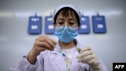 FILE - A technician examines a vile at a laboratory in Shenyang, in China's northeast Liaoning province, June 9, 2020. 