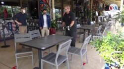 Operarios desinfectan un restaurante en la zona financiera de Miami antes de su reapertura tras la crisis del coronavirus