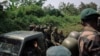 FILE - Soldiers from the Ugandan People's Defence Forces pass soldiers from the 214th DP Battalion of the DRC Armed Forces engaged jointly in Operation Shujaa, on a road between Bulongo and Beni, North Kivu, in the east of the Democratic Republic of Congo, Dec. 17, 2024.