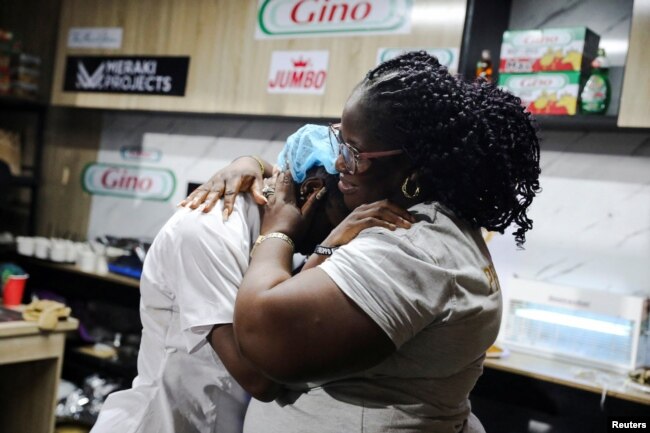 Nigerian Chef Hilda Baci, 27, is hugged by her mother, Lynda Ndukwe, after attempting to break the Guinness World Record for the longest cooking time by an individual, in Lagos, Nigeria May 15, 2023. (REUTERS/Temilade Adelaja)