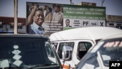 Des voitures sont garées devant des affiches électorales du candidat du Front patriotique au pouvoir Edgar Lungu à la station de taxis du City Market de Lusaka, le 9 août 2021.