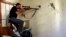 A Free Syrian Army fighter takes a position as he aims his weapon at the Justice Palace, which is controlled by forces loyal to Syria's President Bashar al-Assad, in Aleppo. 