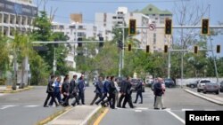 People cross a street with traffic lights out after Puerto Rico Electric Power Authority said a major power line failure in southern Puerto Rico cut electricity to mostl customers in San Juan, Puerto Rico, April 18, 2018. 