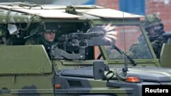 FILE - A Danish soldier fires his machine gun from a vehicle during the NATO Response Force exercise during the NATO Response Force exercise at Oksbol, western Jutland, Denmark, May 16, 2007. 