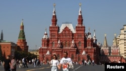 FILE - People walk in Red Square near the State Historical Museum and the Kremlin wall in central Moscow, Sept. 10, 2024. 