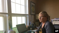 Realtor Michelle Bushée poses at her desk while working from her home in Pittsburgh, Pennsylvania, April 3, 2020. Her weeks used to be very busy but now the entire month of April is empty. 
