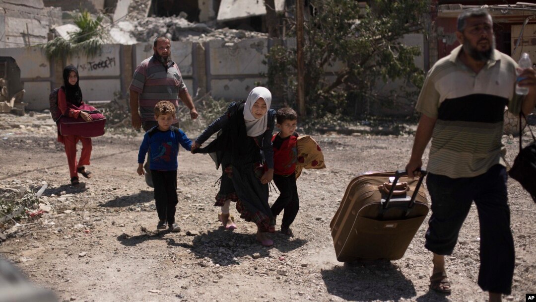 Devojčica pognuta beži sa braćom u deo grada al-Rifai, dok se iračke specijalne jedinice bore protiv Islamske države u zapadnom Mosulu, irak, 17. maja 2017. (AP Photo/Maya Alleruzzo)