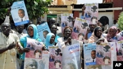 Sudanese supporters of former SPLM candidate Yasser Arman hold his posters during a protest against his withdrawal from the presidential race in Khartoum, 04 Apr 2010