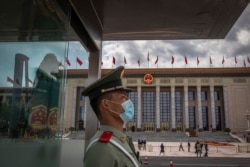A Chinese People's Liberation Army (PLA) soldier wearing a protective face mask stands guard in front of the Great Hall of the People before the second plenary session of China's National People's Congress (NPC), in Beijing, May 25, 2020.