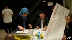 Une femme dans un bureau de vote à Istanbul, Turquie, dimanche 14 mai 2023.